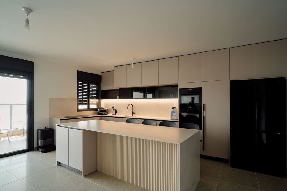 Apartment kitchen with an island and built-in appliances