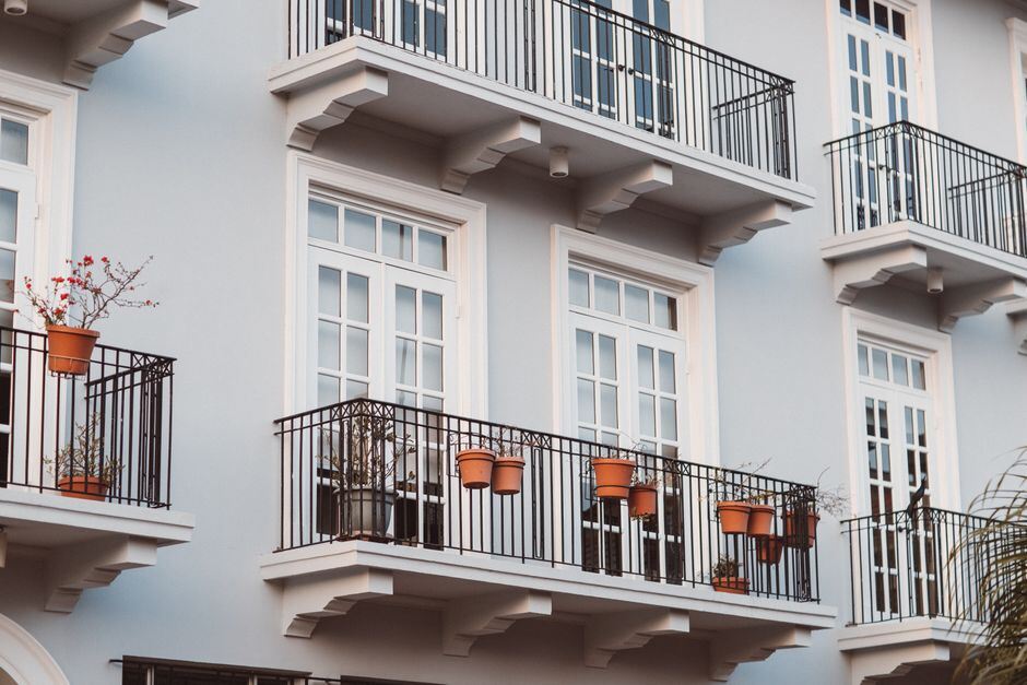 Balconies with potted plants on a white building facade