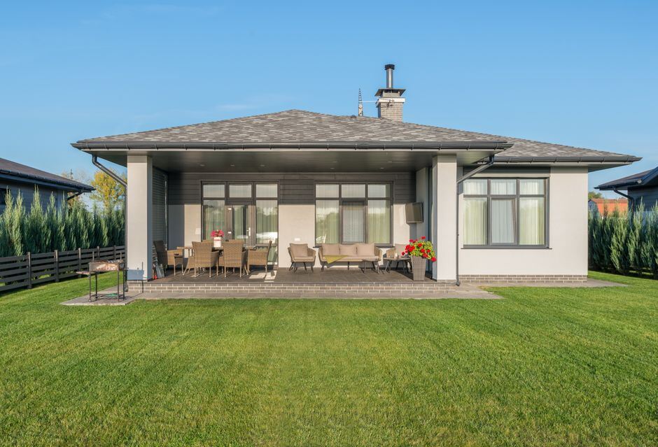Covered porch facing a wide back lawn