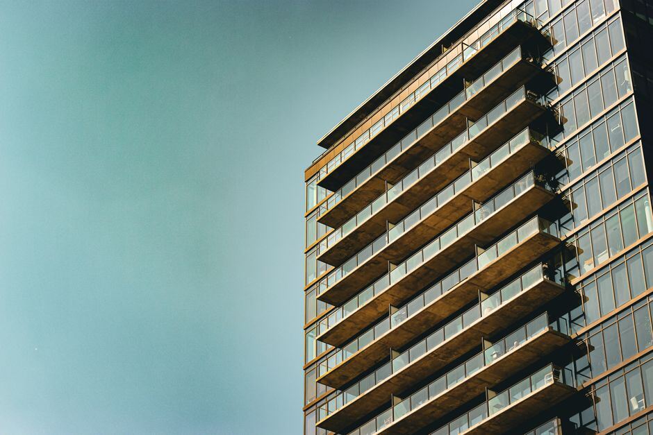 Glass apartment tower with rows of balconies