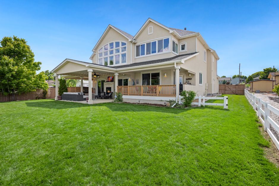 Two-storey house behind a fenced back lawn