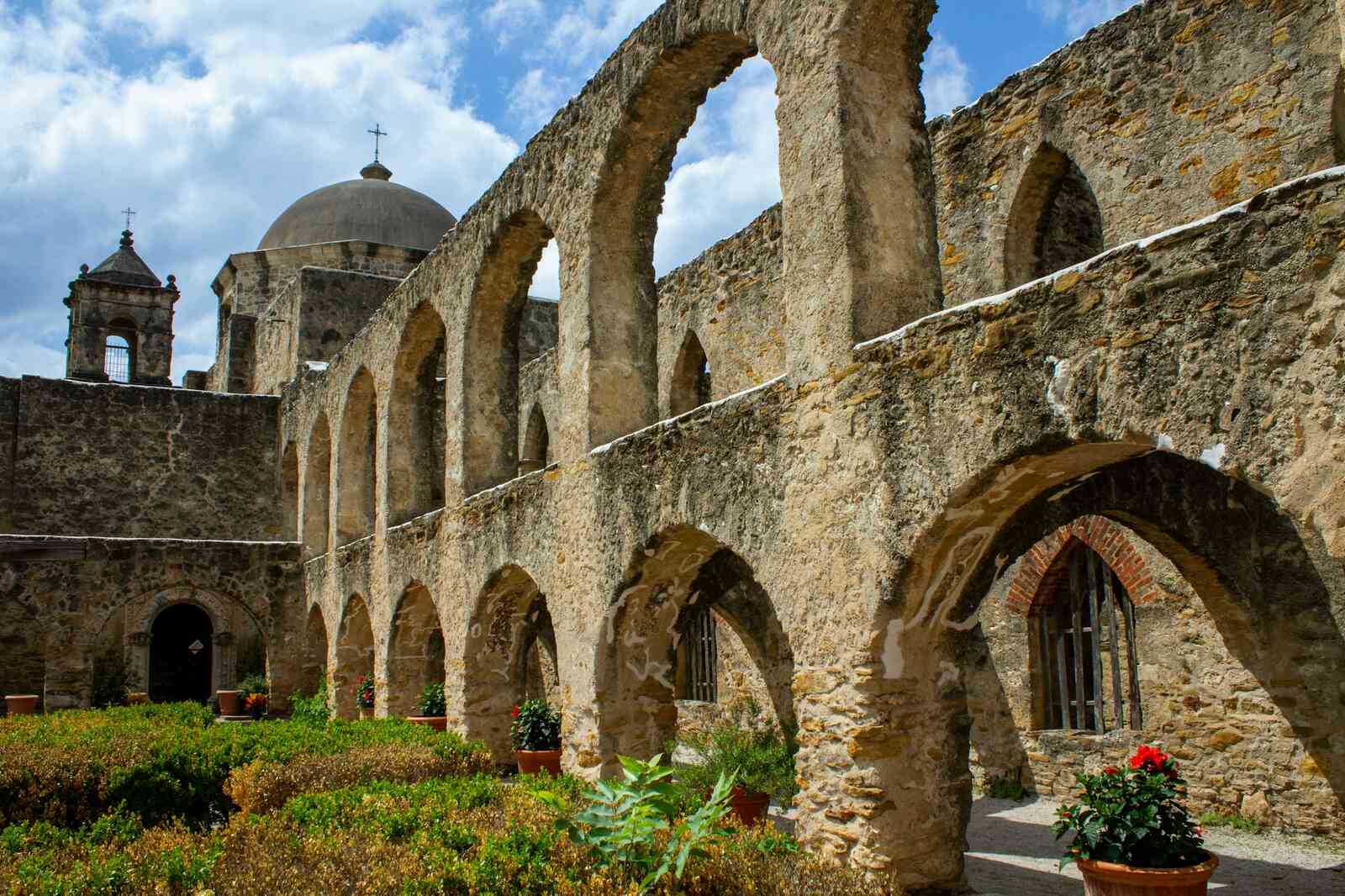 Stone arcade and garden courtyard at a San Antonio mission