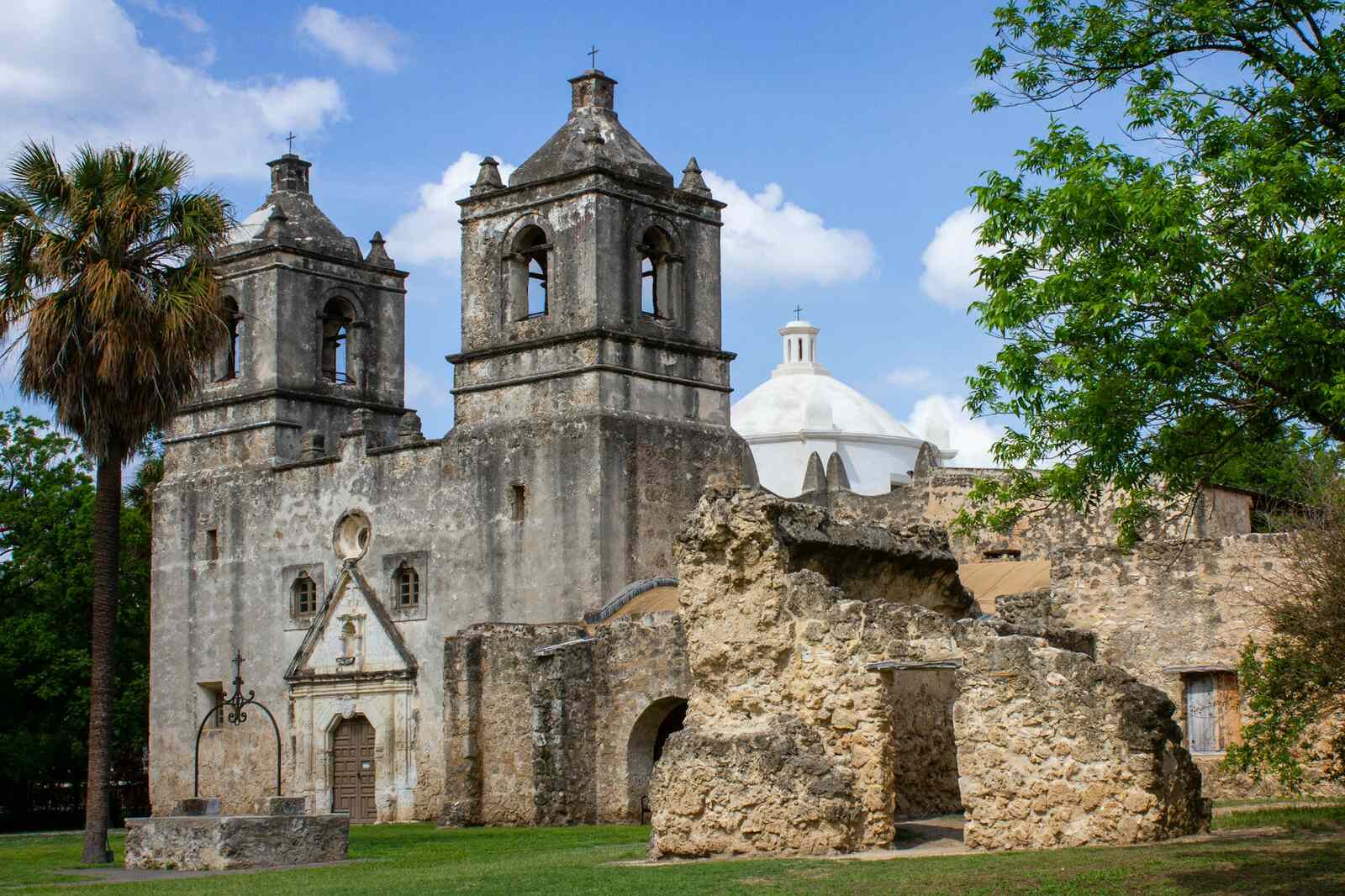 Historic mission church with twin bell towers and palms in San Antonio